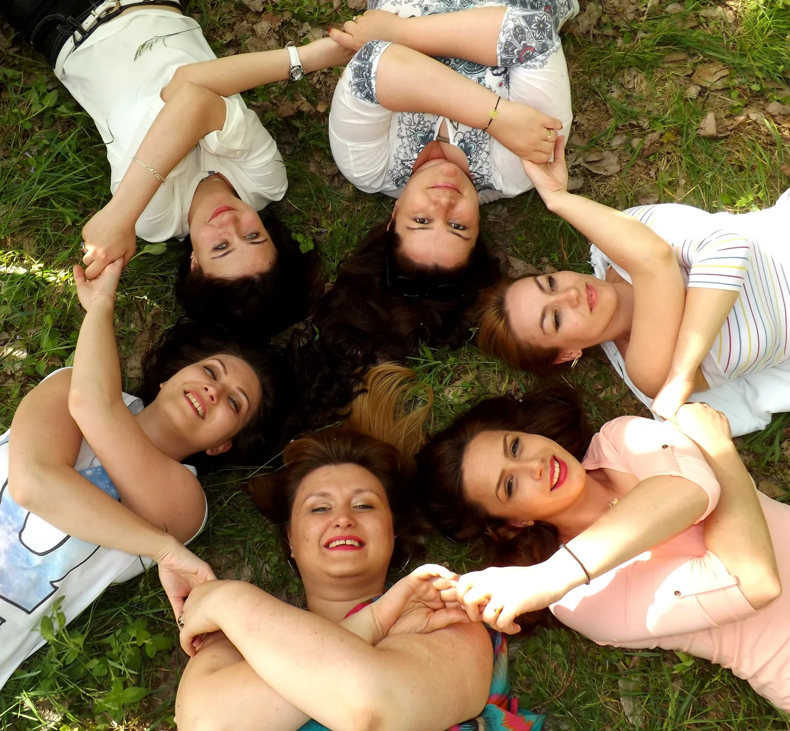 Des femmes allongées en cercle dans l'herbe