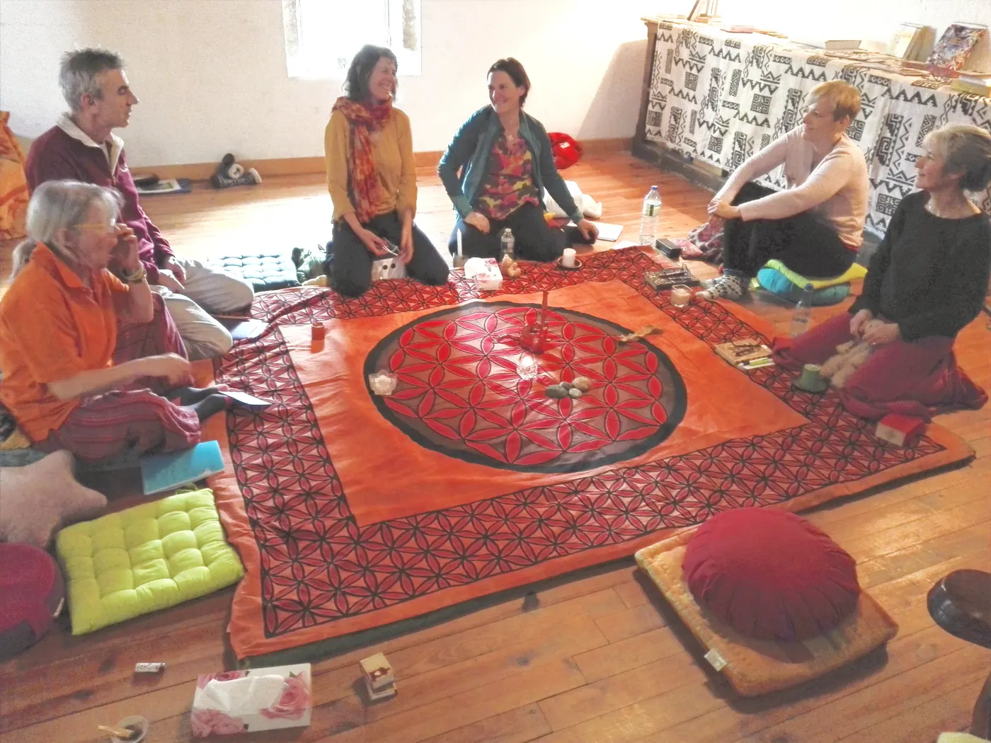 Un cercle assis autour d’un tapis fleur de vie
