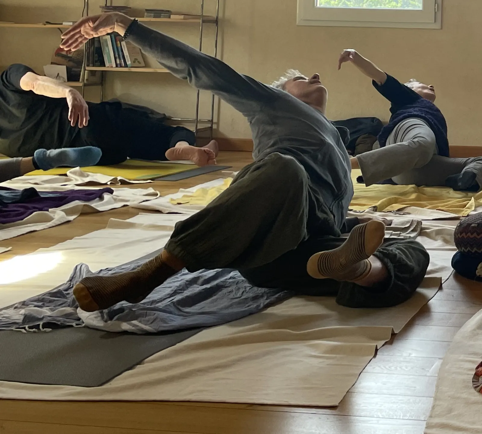 Un cours de yoga dans la salle de Vézénobres : étirement latéral au sol, les bras tendus